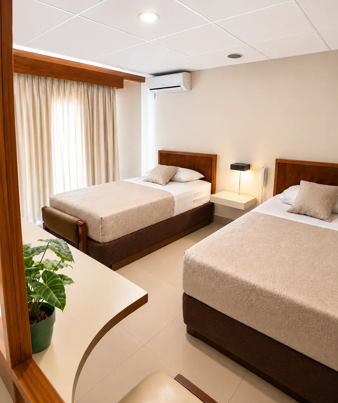 Habitacion triple del Hotel Laja City con dos camas, aire acondicionado y telefono